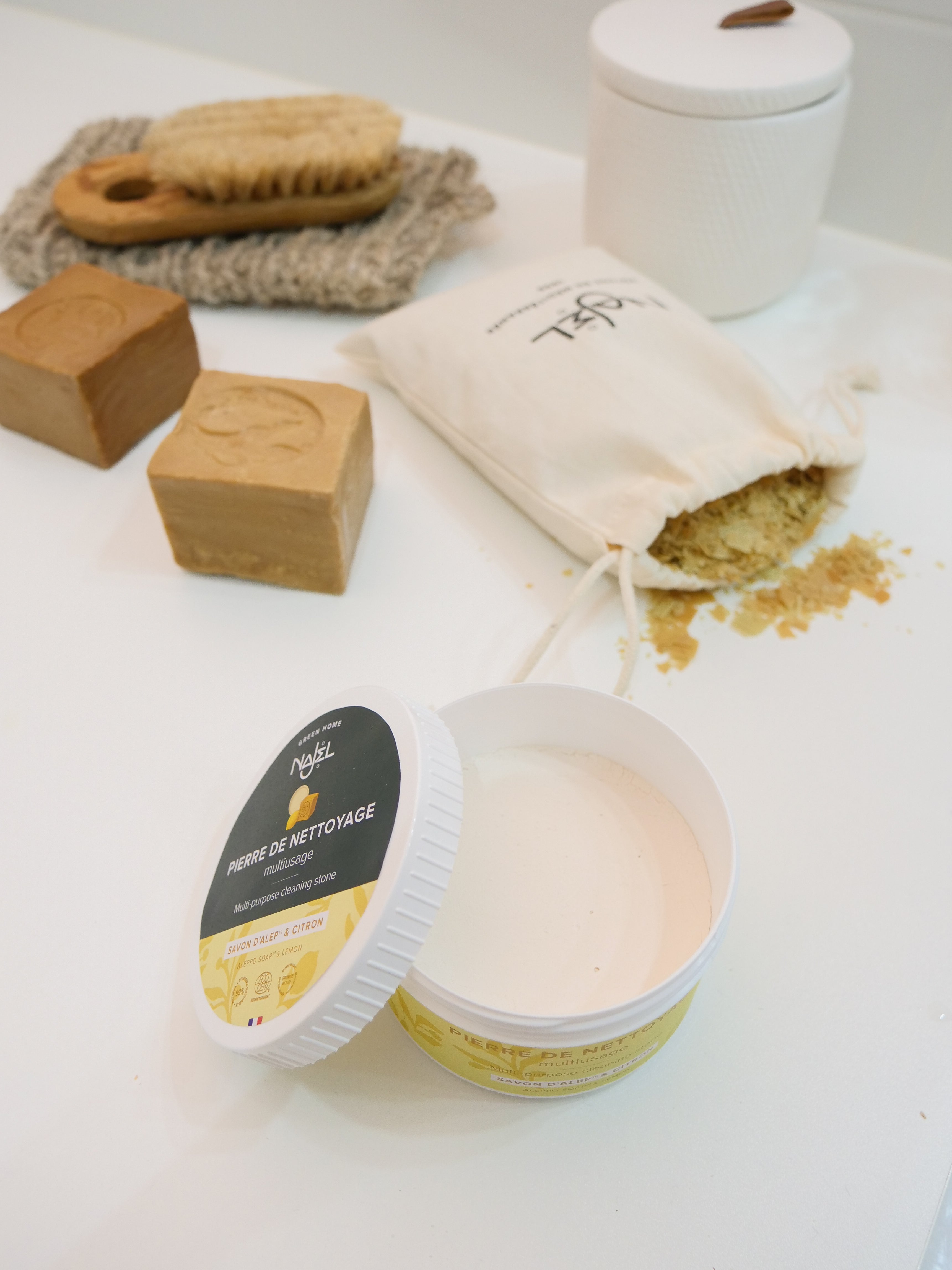 Pierre nettoyante Najel à base de savon d’Alep et d’huile essentielle de citron, présentée dans son pot ouvert avec texture solide visible.