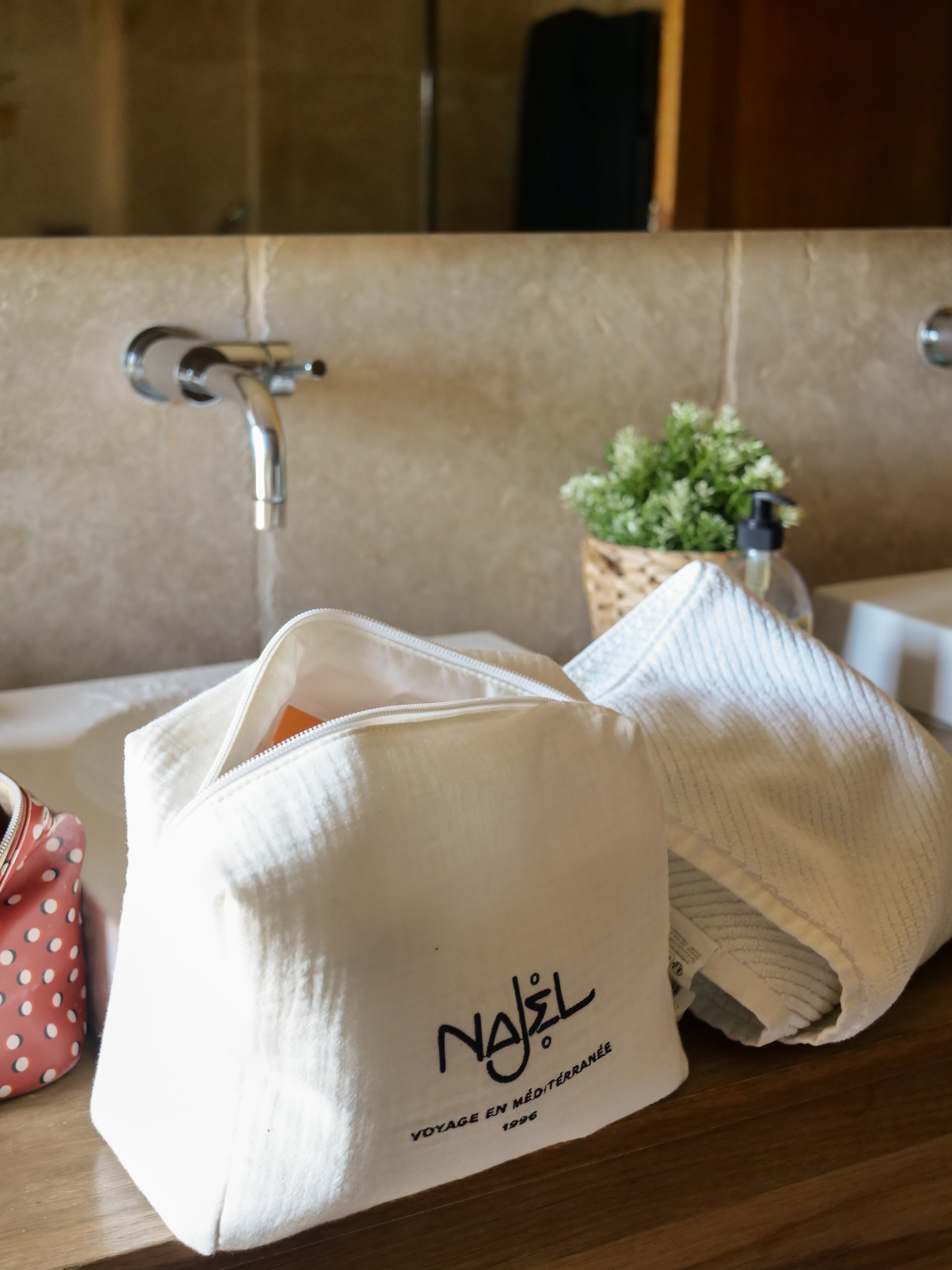 Trousse de toilette Najel ouverte sur plan de travail salle de bain